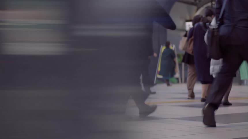 People walk through an indoor urban area while motion blur crosses the foreground