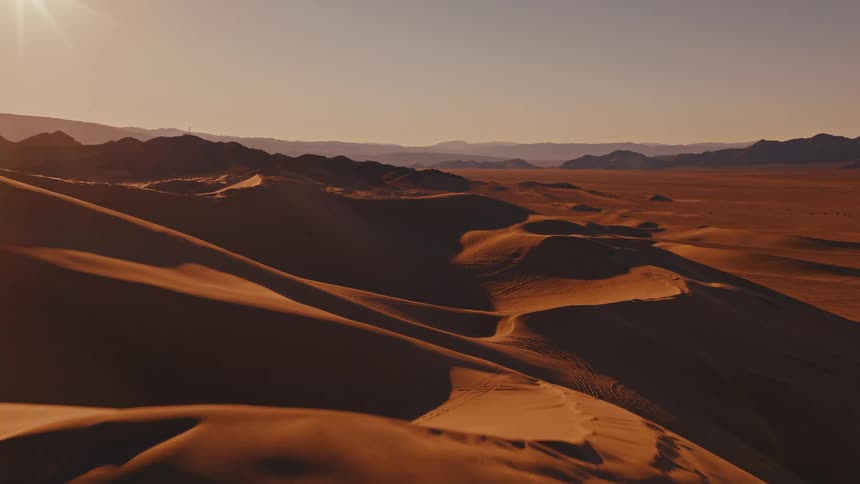 Aerial footage of flying above numerous large desert sand dunes