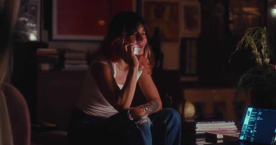 The woman is talking on her cell phone at home