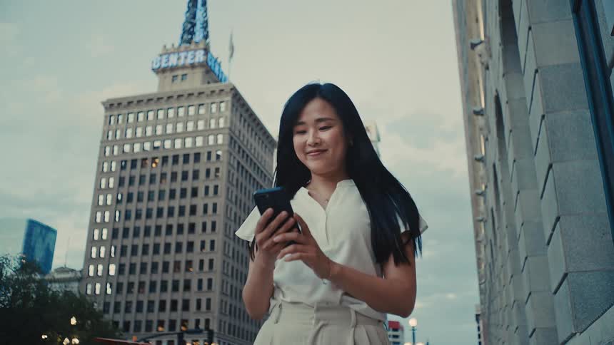 Woman interacting with a smartphone while walking through the city