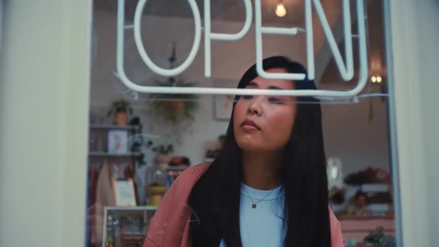 Woman turning off the open sign at a store