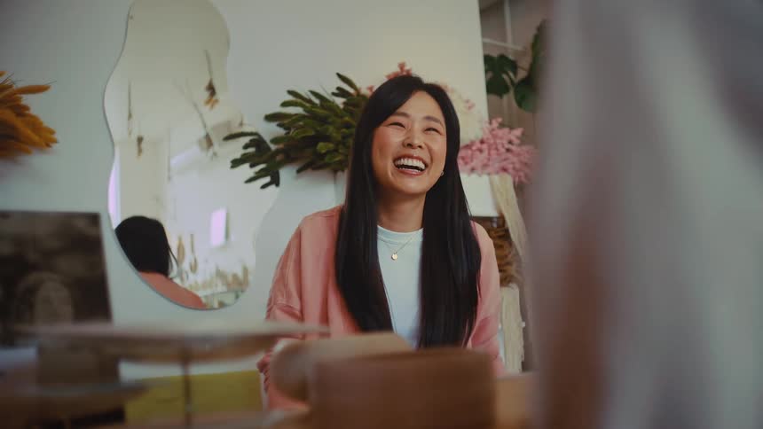 A woman laughs and smiles warmly in a stylish boutique