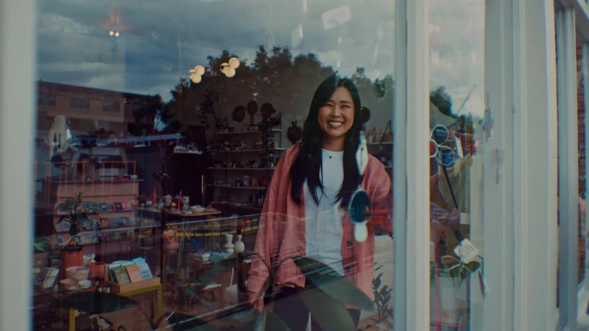 The employee smiles inside the shop window