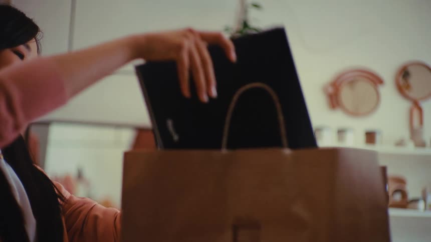 A woman putting items in a bag to give to a client