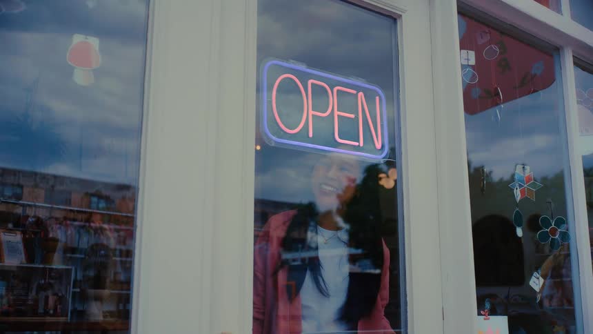 The worker turns on the open sign in the shop