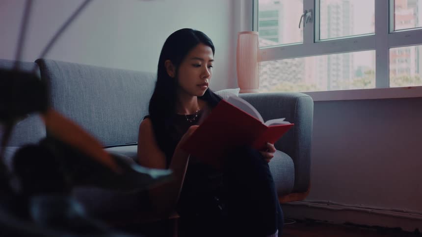A woman reading a book in a room
