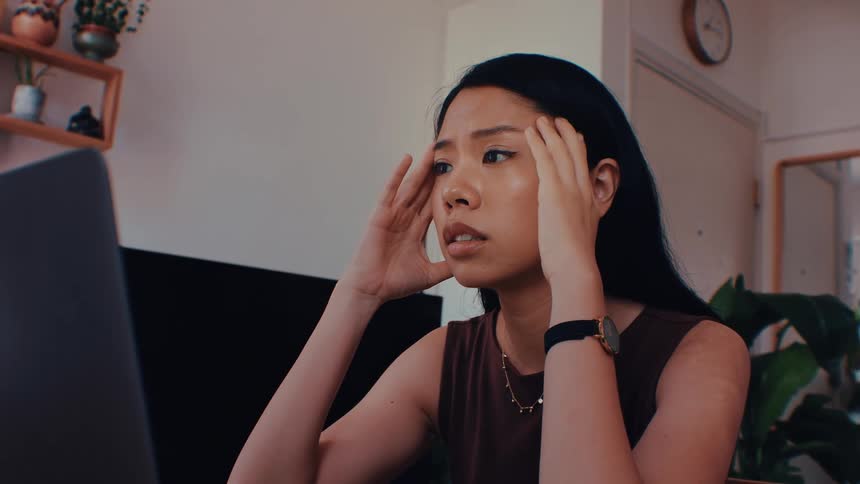 The woman gets nervous while looking at her laptop