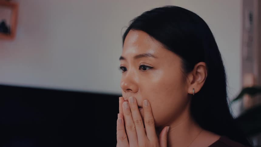 The woman puts her hand on her face while thinking