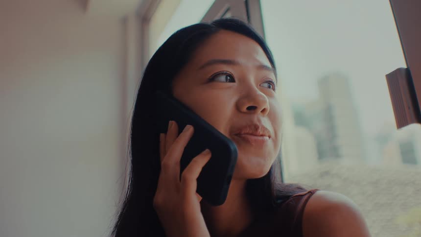 A woman talking on a smartphone in a room