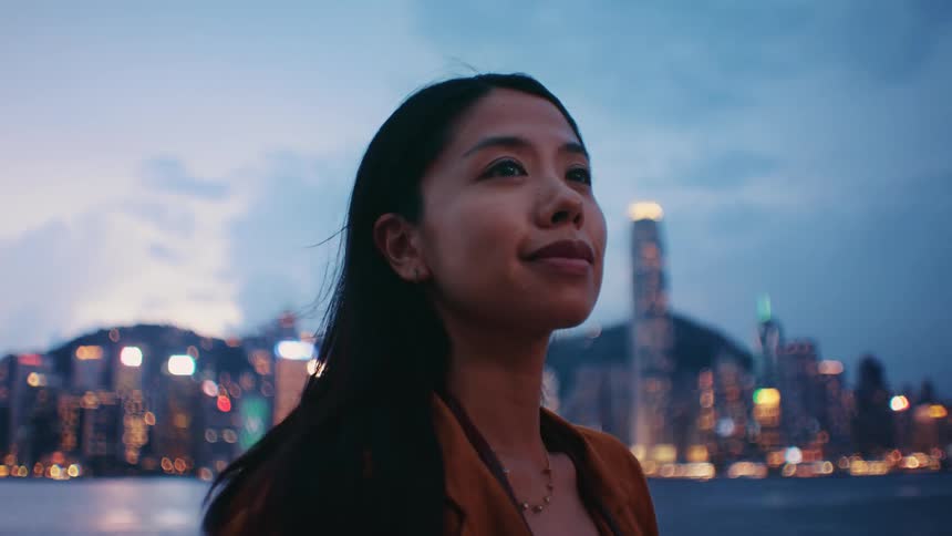 The woman smiles on the shore of the big city