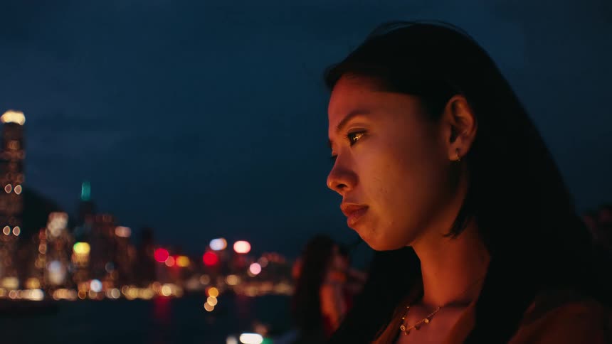 A woman standing outdoors at night