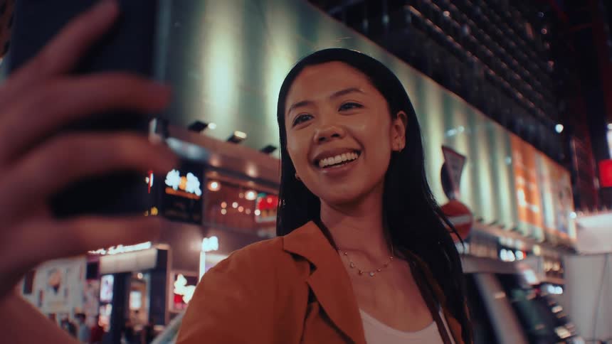 The woman takes selfies in the city at night