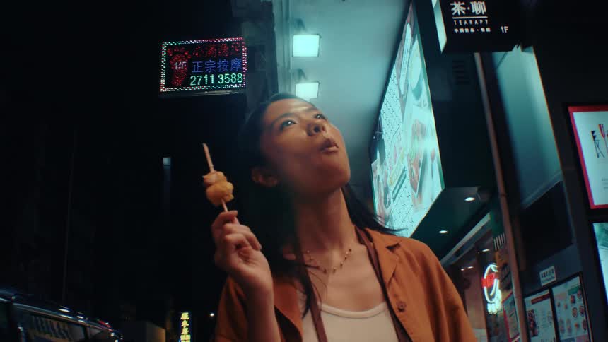 The woman walks through the city while eating