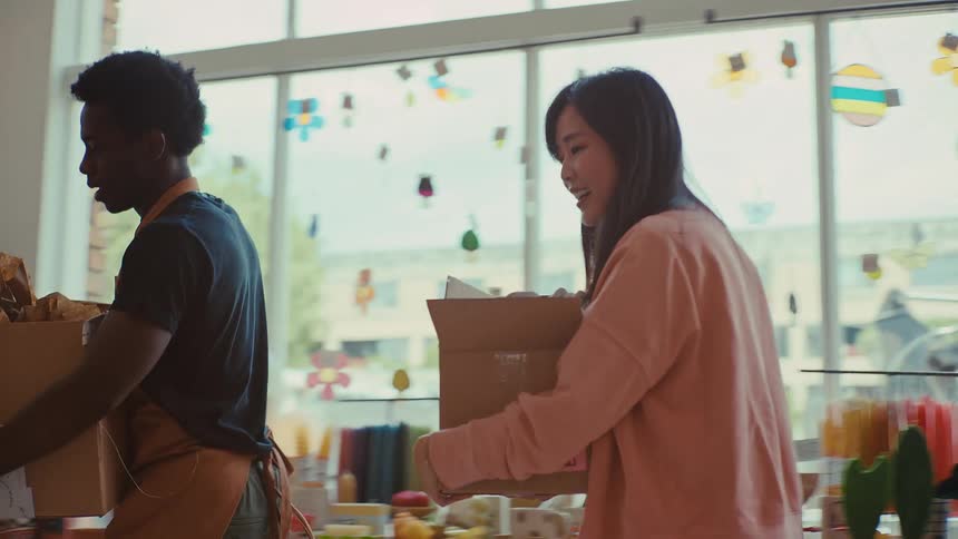 Man and woman carry boxes inside a resale shop