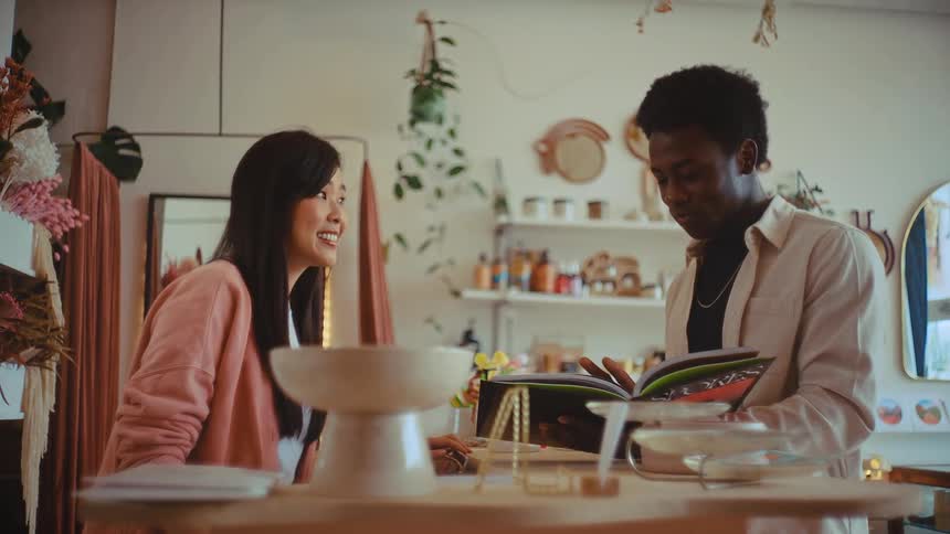 Woman working at a store showing things to a man