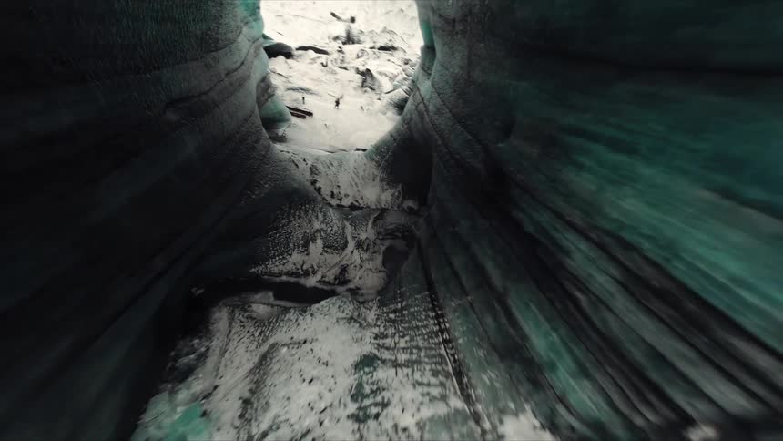Ice wall shows compacted layers with bluish tones and visible fractures