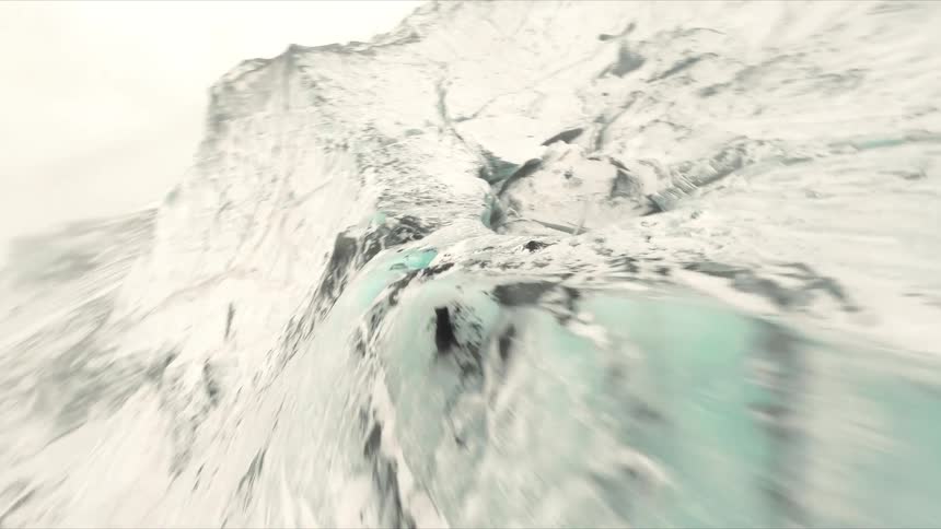 A high speed drone captures a thrilling flight over jagged glacier ridges and down into a deep ice crevasse