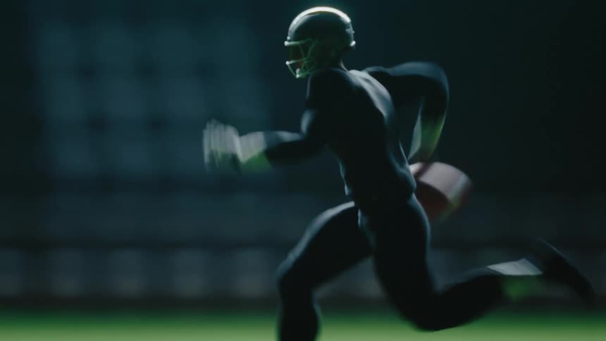 Young adult man wearing a football helmet running on a field carrying a football on his hand outdoors during night time