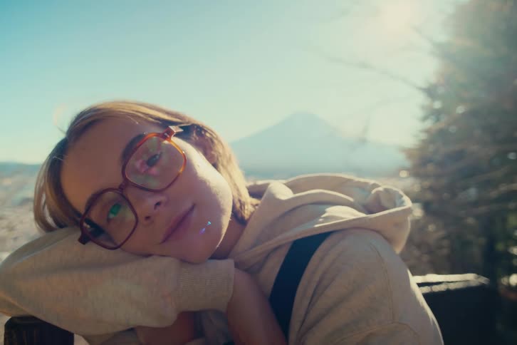 A portrait of a woman in a hoodie outdoors