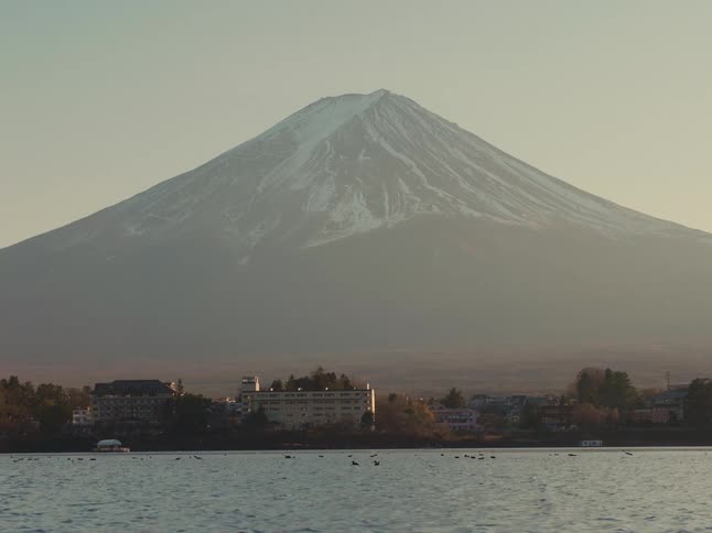 Fog covers the mountain towering over a nearby coastal town on a winter day