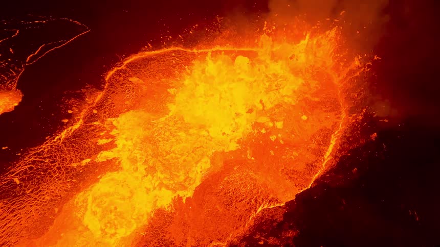 An aerial orbit captures a bubbling lava pool at night where molten orange rock churns and splashes with intense heat illuminating the dark volcanic landscape with a rhythmic fiery glow
