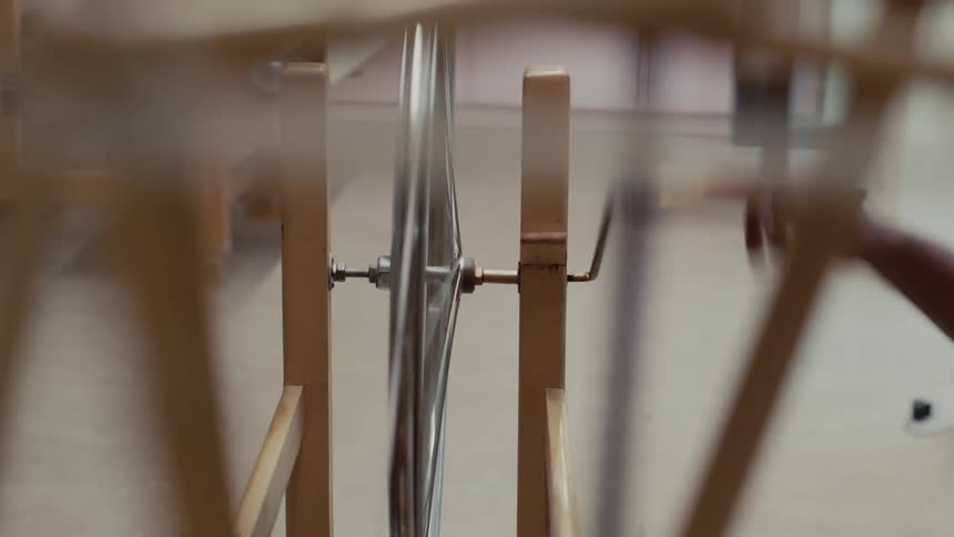 A person cranking a wheel in a factory