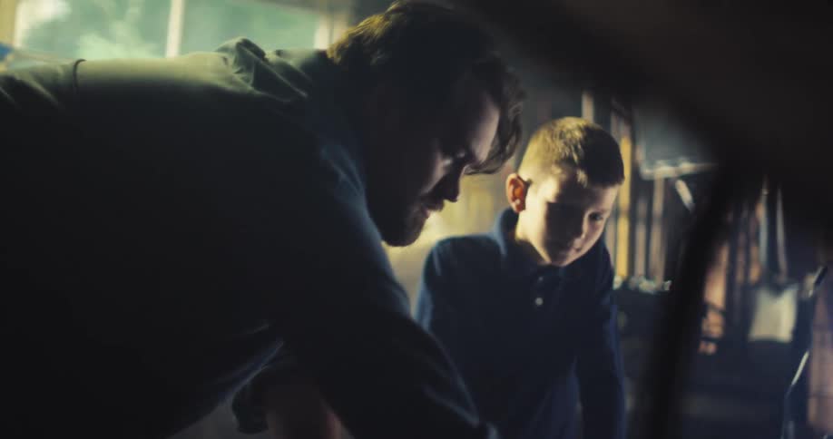 A father and son looking at an engine
