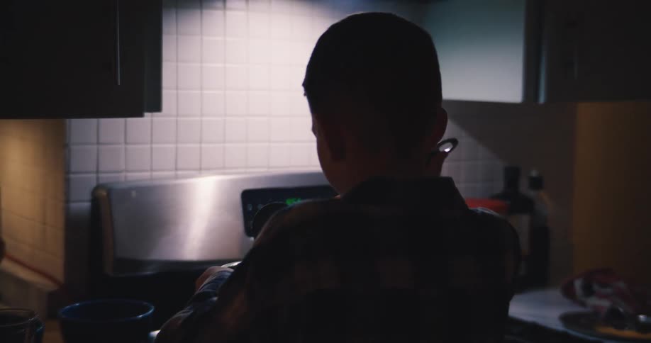 The boy fills his bowl from the pot