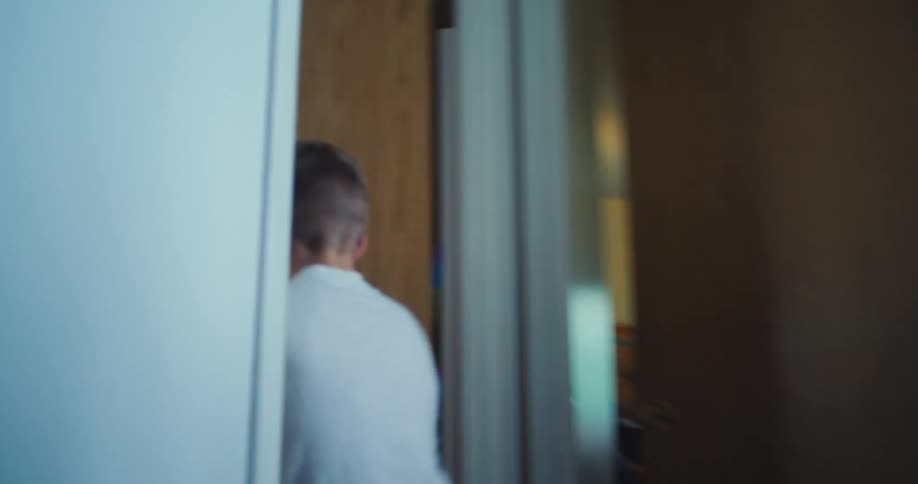Boy running down the hallway enters a room and slams the door