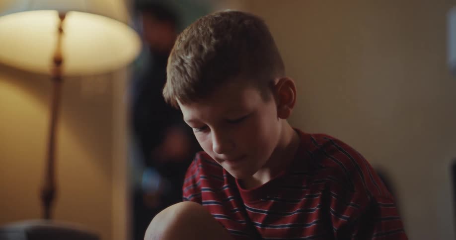 When the man leaves the home the boy watches him through the window