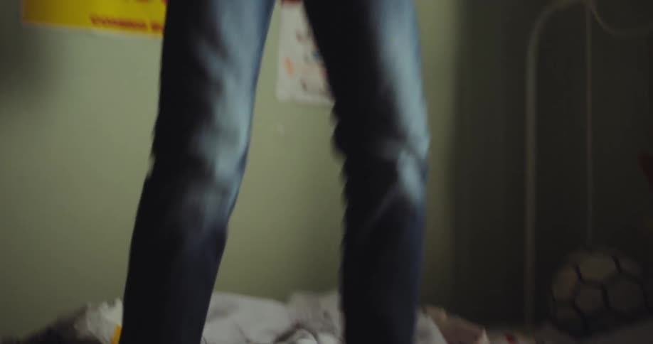 A joyful young boy jumps energetically on his bed
