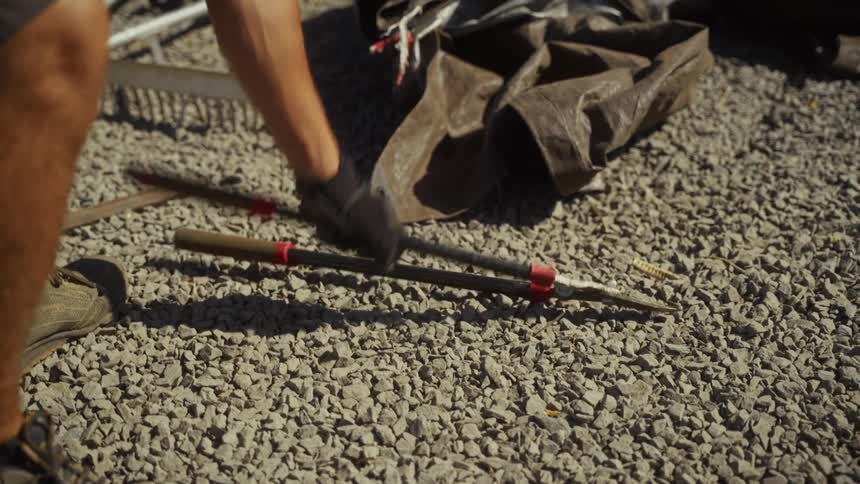 Gloved hand holding a pair of gardening shears