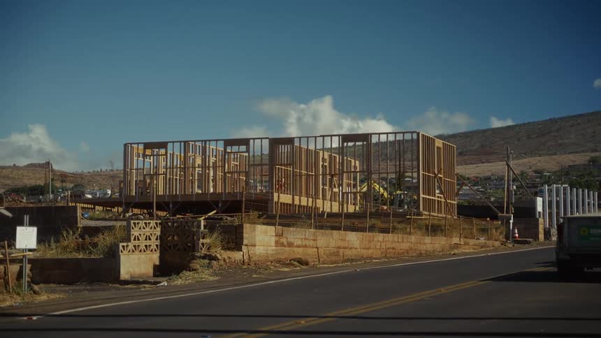 House under construction with mountains in the background