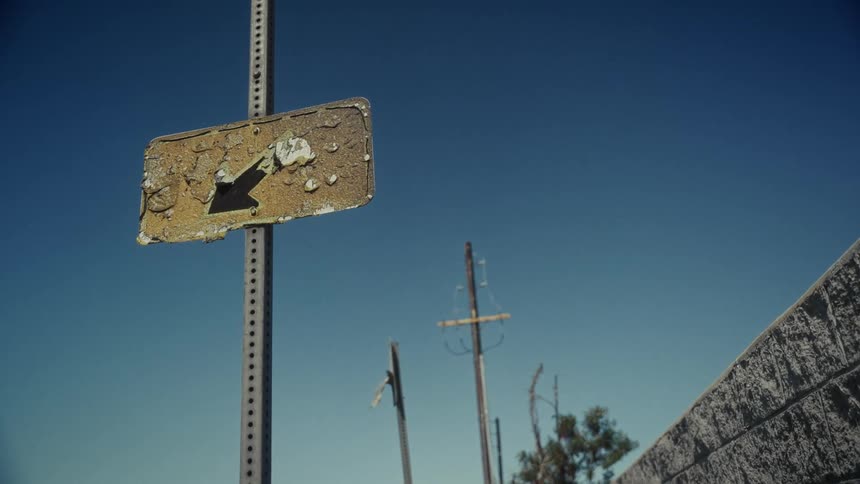 Wind is blowing the old sign on a sunny day