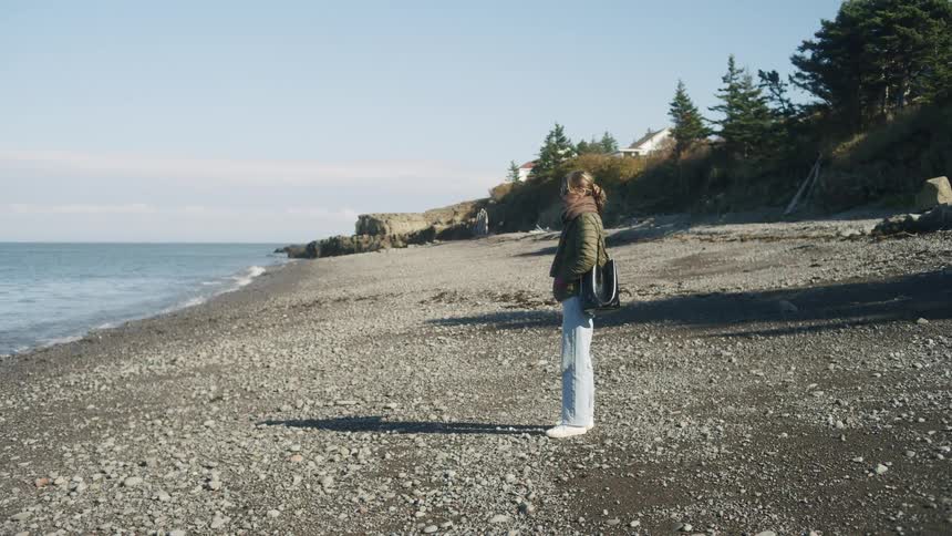 A woman standing on a beach in the winter