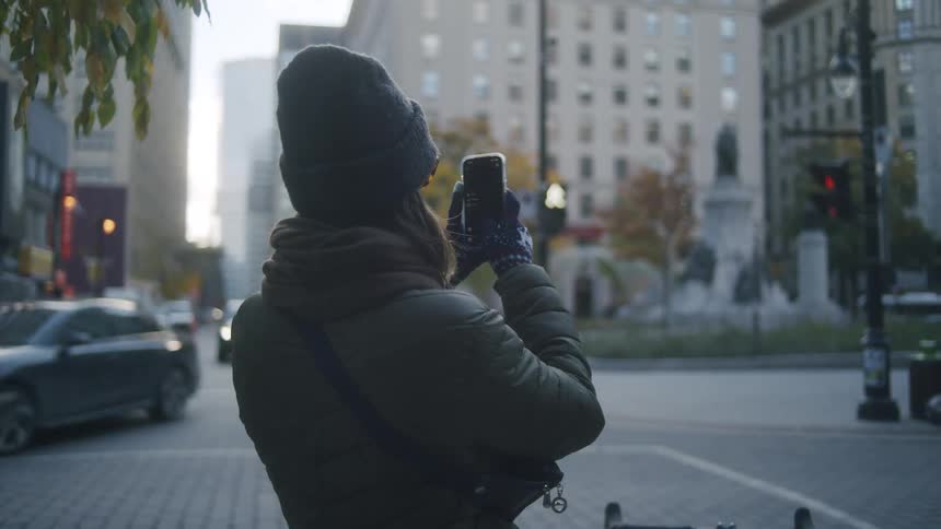 Woman taking photos of an intersection with her cell phone