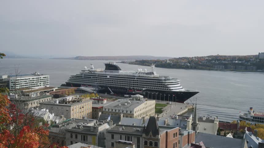 Buildings along the coast overlook a cruise ship docked in the harbor