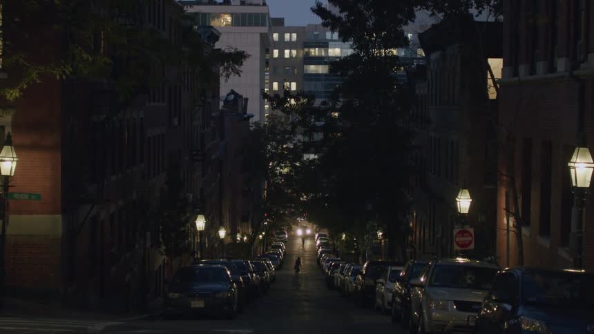 Urban street with cars parked at night