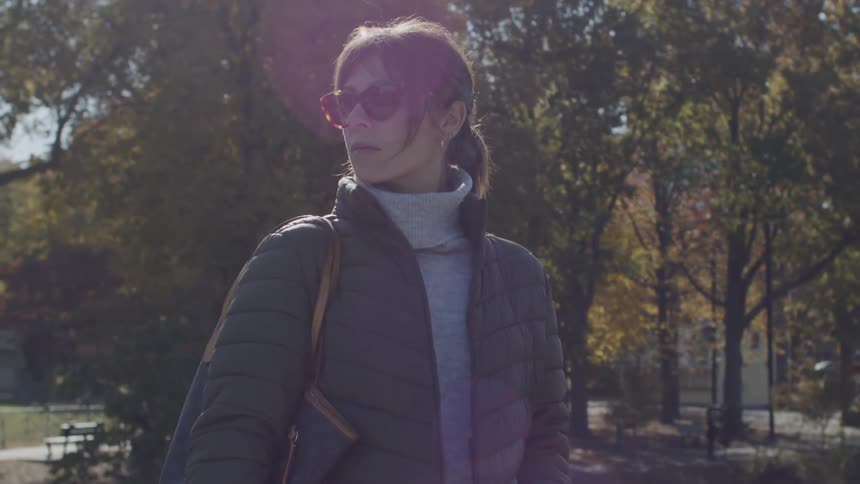 The woman is looking around the park
