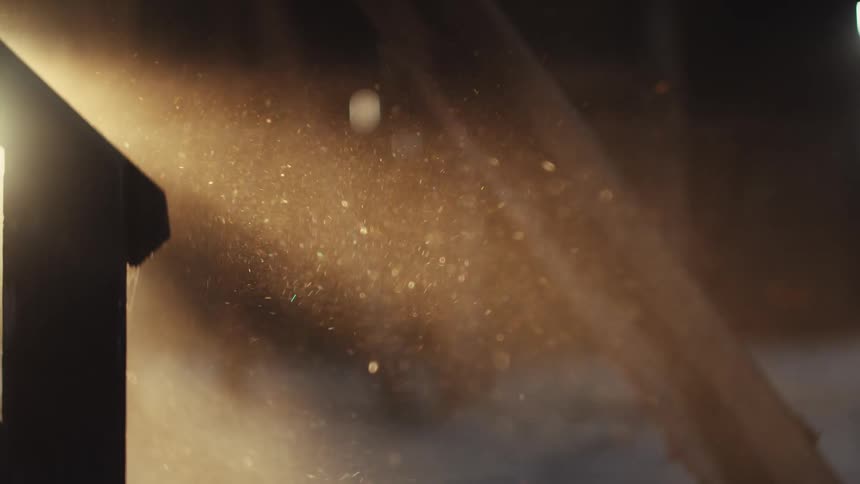 Speckeles of dust floating on sunlight in a room filled with wooden items indoors during dusk or dawn