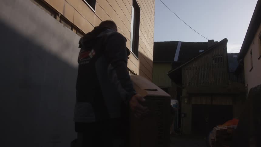 A delivery person carrying a box outdoors