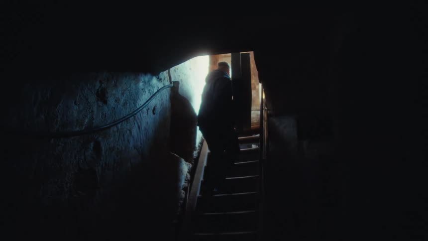 Man climbing the basement stairs with equipment