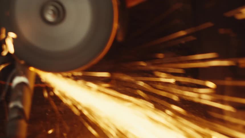 Metal pipe being cut with sparks from highspeed abrasive disc
