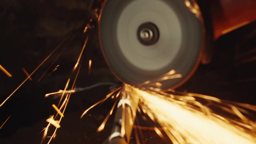 Grinding metal rod with intense sparks in motion