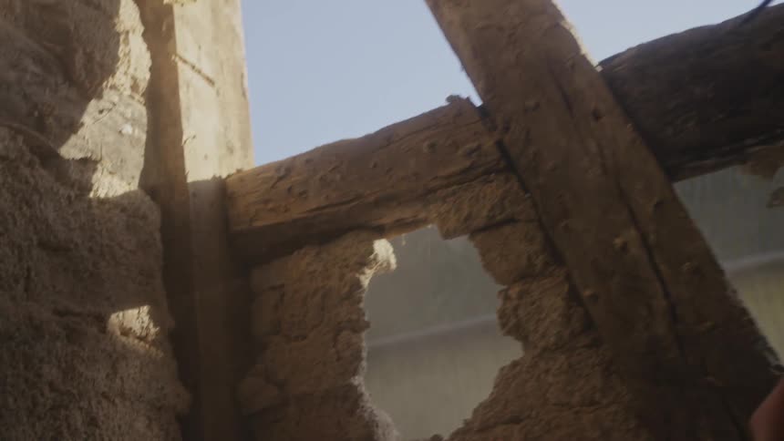 Person with a sledgehammer breaking down a brick wall