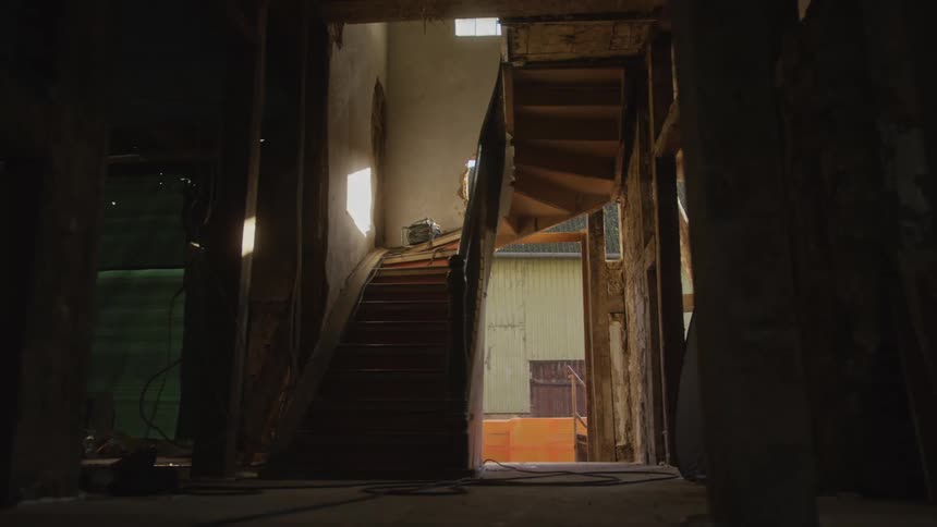 Wooden staircase and rooms on an unfinished house indoors during day time