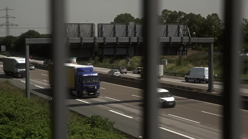 Trucks and cars move in traffic in both directions on the freeway
