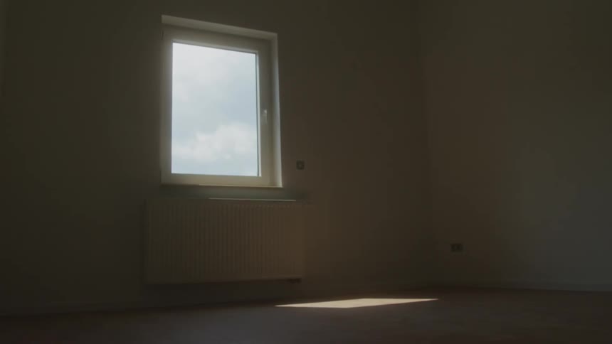 Empty room with natural light entering through window above radiator