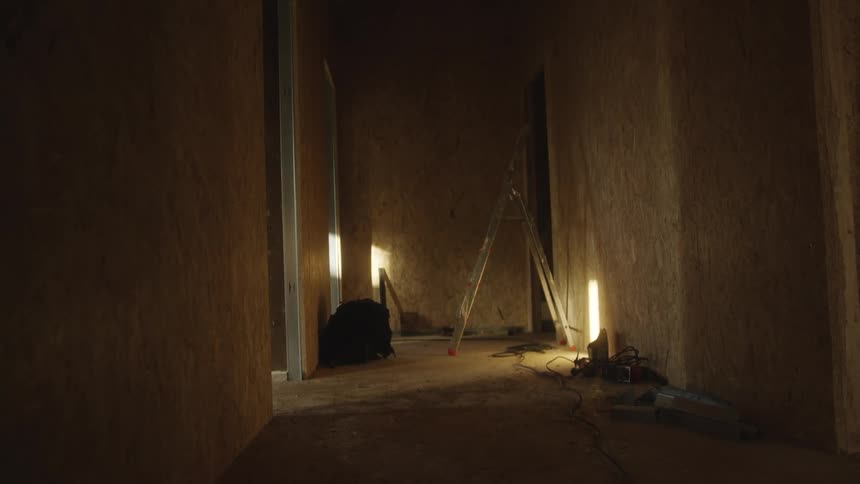 Hallway under renovation with central ladder and vertical lights turned on