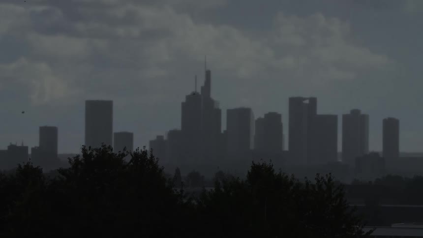 Urban skyline with modern buildings silhouetted against cloudy evening sky